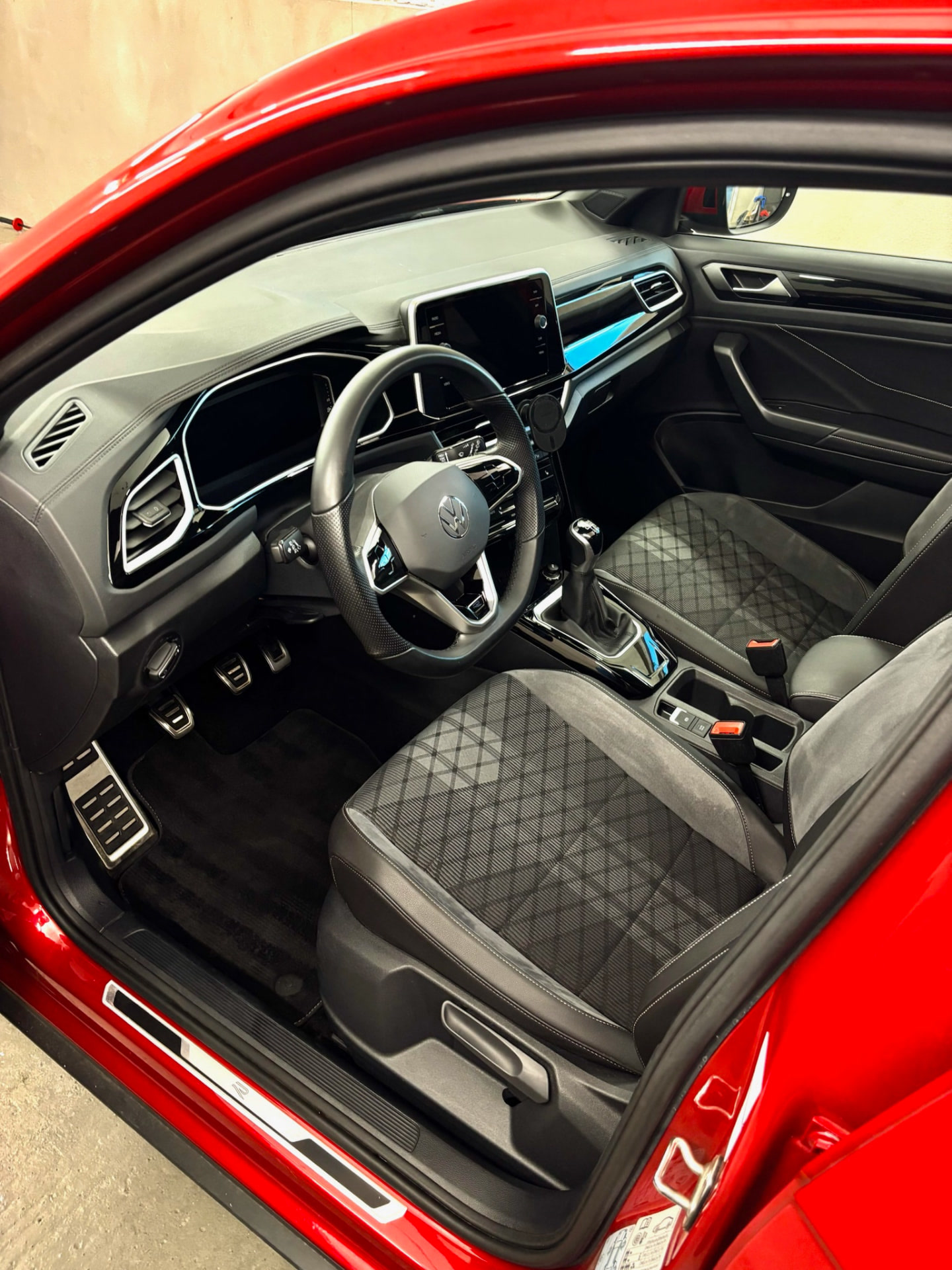 Innenraum eines roten VW T-Roc mit gereinigtem Cockpit und Rautensitzen